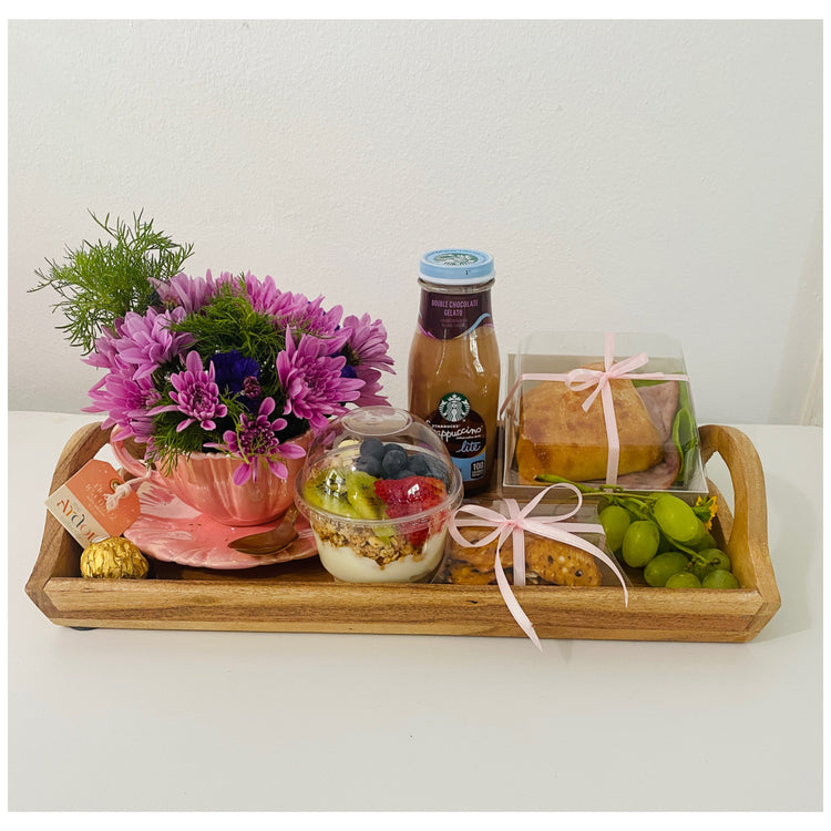 Delicioso Desayuno, con flores decoradas dentro de un set de taza y plato de té